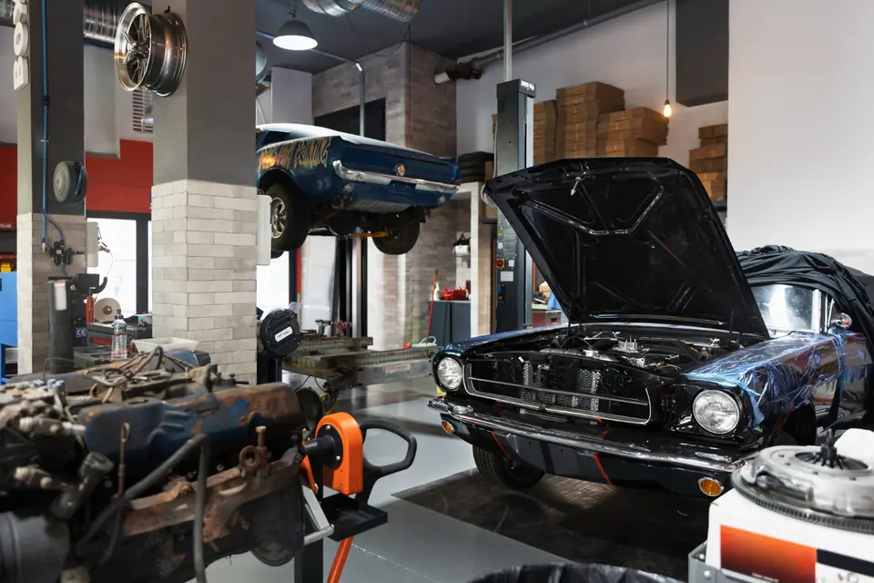 Auto repair workshop with a car on a lift and another with its hood open