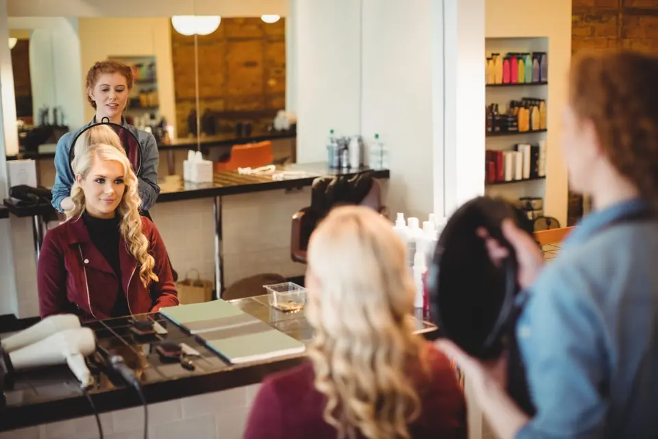 Hair stylist showing a client her new style in a salon mirror